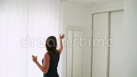 女人打开卧室的窗帘喝橙汁视频的预览图