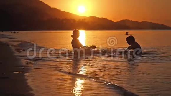 快乐的一对在海滩度假海水缓慢地拍打着日落1920x1080视频的预览图