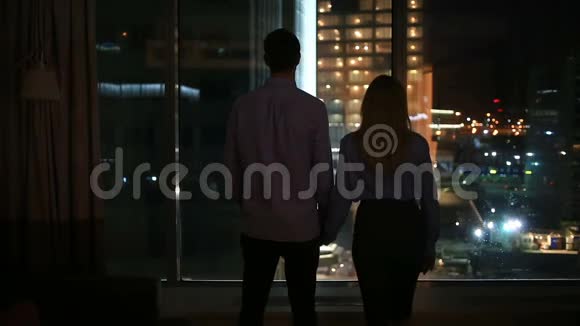 一对男女在夜市的大窗户里张望拥抱视频的预览图