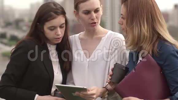 一群商人在平板电脑的屏幕上互相交谈和展示信息三个女孩视频的预览图