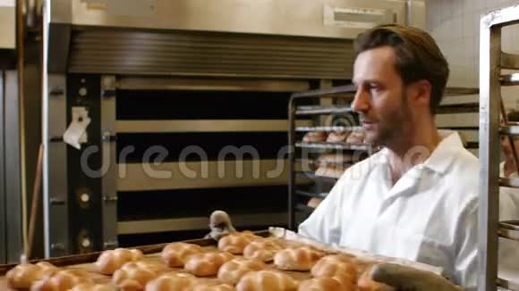 面包师在烤车上放烤麦片视频的预览图