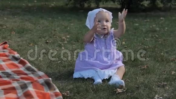 一个坐在草地上的女婴举手视频的预览图