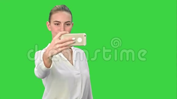 女商人在绿色屏幕上用手机拍摄有趣的自拍Chroma键视频的预览图