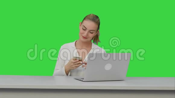 快乐的女人正在自己跳舞使用智能手机在工作场所的绿色屏幕Chroma键视频的预览图