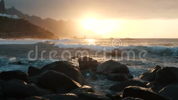 在加那利群岛的特内里费海浪撞击岩石在美丽的日落光线下喷射慢动作视频的预览图