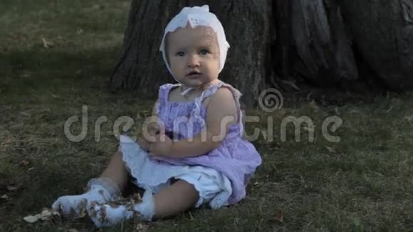 一个穿着白色袜子坐在草地上的女婴视频的预览图