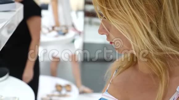 金发女人在一家鞋店里挑选鞋子4k慢动作视频的预览图