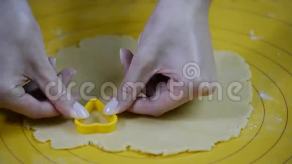 女人的手切饼干从面团中分离出来视频的预览图