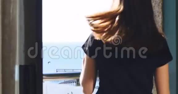 年轻女士在酒店房间的阳台上享受阳光视频的预览图