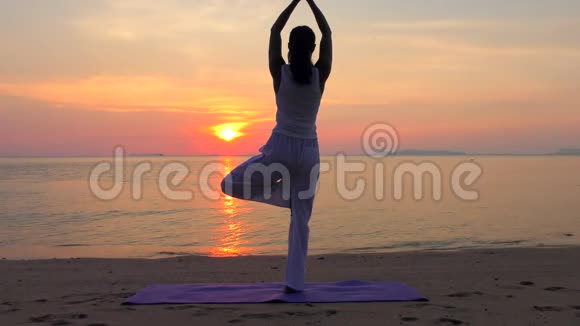 亚洲女子在日落海练习瑜伽视频的预览图