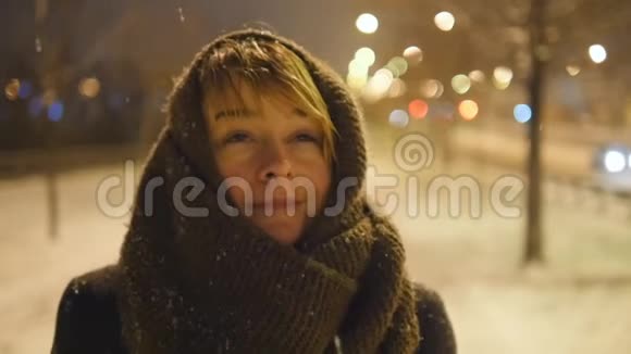小女孩站在街上慢慢地享受着降雪的乐趣视频的预览图
