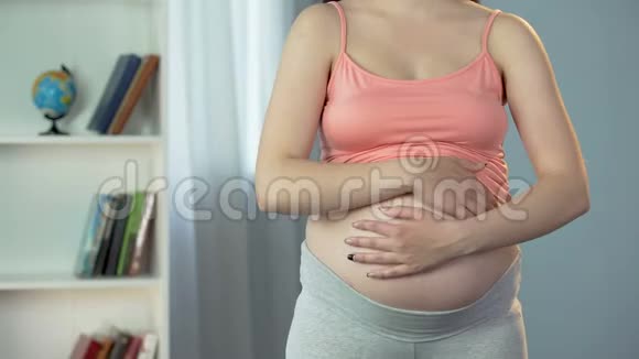 孕妇的双手用爱抚摸和摩擦腹部期待宝宝视频的预览图