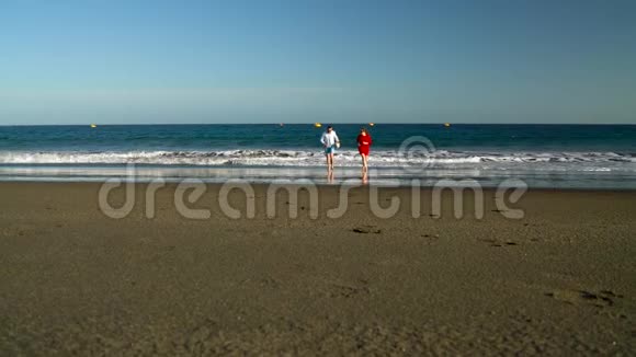 恋爱中的夫妻无忧无虑地从海滩上的水中奔跑加那利群岛特内里费海岸图片视频的预览图