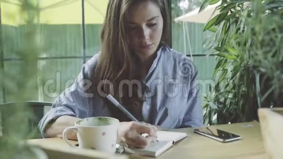 女人在咖啡馆写日记学习视频的预览图