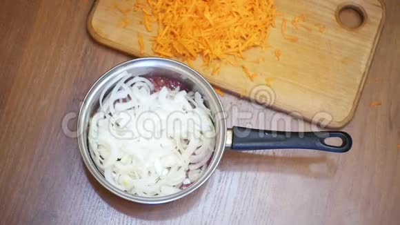 在家庭厨房中加入磨碎的胡萝卜准备食物慢动作视频的预览图