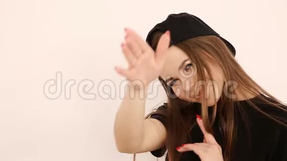 穿着时髦的嘻哈服装和戴着白墙造型的帽子的少女视频的预览图