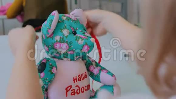 裁缝女人玩具熊把蝴蝶结系在泰迪熊脖子上视频的预览图