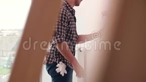 男人在新公寓里粉刷内墙视频的预览图