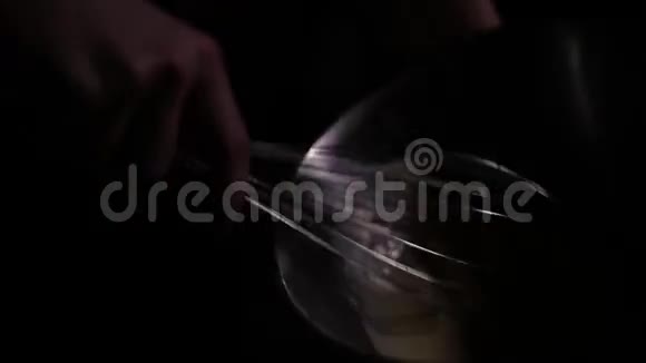 人在黑暗中搅动盘子里的鸡蛋视频的预览图