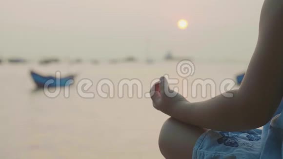 可爱的小女孩在海边以土耳其式冥想视频的预览图
