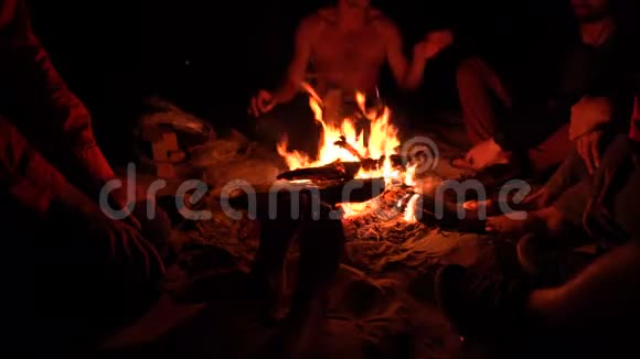 一群朋友晚上坐在篝火旁闲逛4KUHD视频的预览图