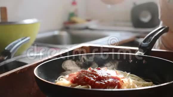 在煎锅中用红番茄酱煮和搅拌意大利面视频的预览图