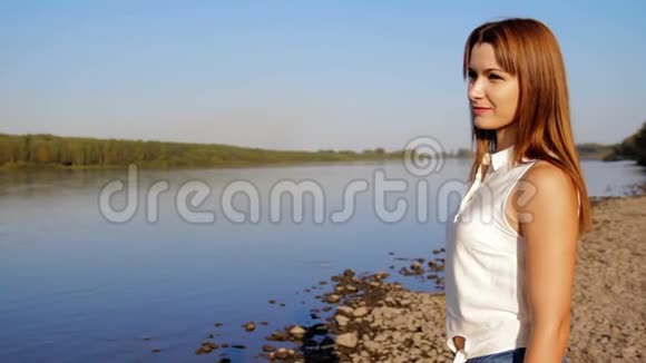 站在河岸上的女人河岸上微笑的女人的肖像视频的预览图