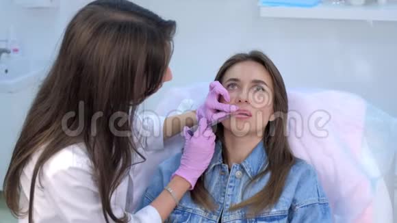 美容师在美容诊所的病人嘴唇上注射视频的预览图