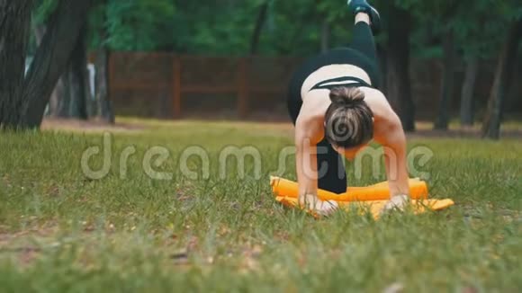 体育运动中的年轻运动员妇女参与健身躺在草坪上的公园里的地毯上视频的预览图