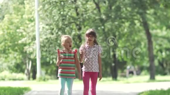孩子们在夏天的公园里散步吃冰淇淋小女孩用冰淇淋抹脸视频的预览图