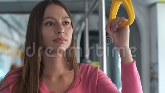 年轻女性乘客在公共交通工具上享受旅行站在现代电车上视频的预览图