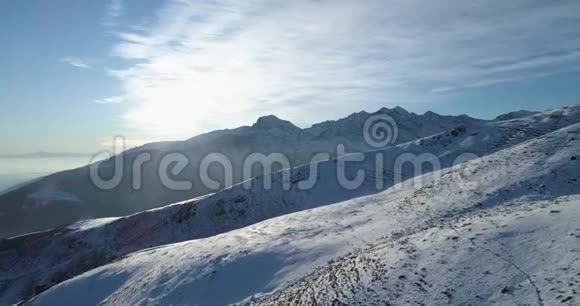 在阳光明媚的日子里用滑雪道向前俯瞰冬天的雪山白色背景阿尔卑斯山视频的预览图
