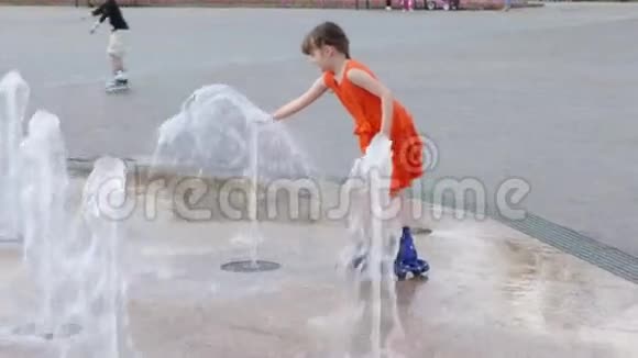 夏天的小镇上快乐的女孩在溜冰鞋上玩干涸的喷泉视频的预览图