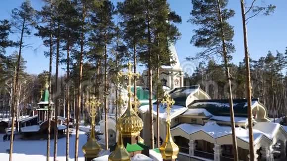 在俄罗斯冬季古老的教堂倾斜着山上有白色的树木冬天森林里的神庙视频的预览图