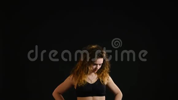 女孩在黑色背景下做颈部锻炼视频的预览图