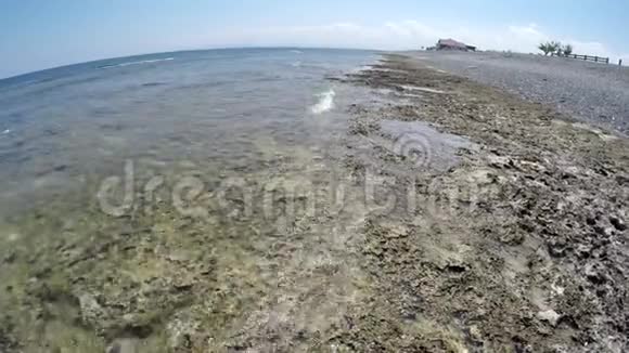 黑色的鹅卵石排在开阔的海洋的岸边视频的预览图