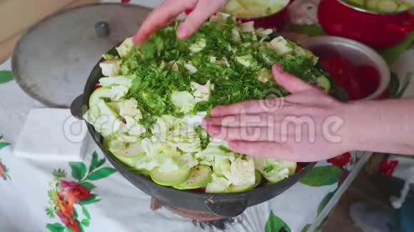 白色厨师的手把盐倒在切好的卷心菜上放在大锅里里面有蔬菜视频的预览图
