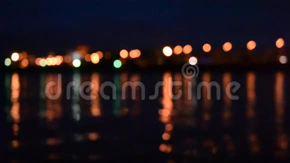 夜间交通没有焦点的城市灯反射在水中视频的预览图