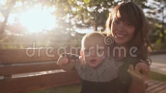 快乐的年轻妈妈陪宝宝玩散步他们得到了阳光视频的预览图