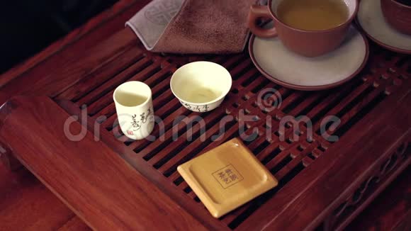 中国传统茶道的动作把茶壶里的茶倒在杯子里放在竹垫和视频的预览图