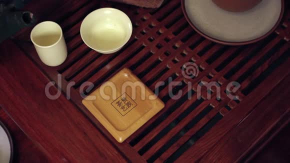 中国传统茶道的动作把茶壶里的茶倒在杯子里放在竹垫和视频的预览图