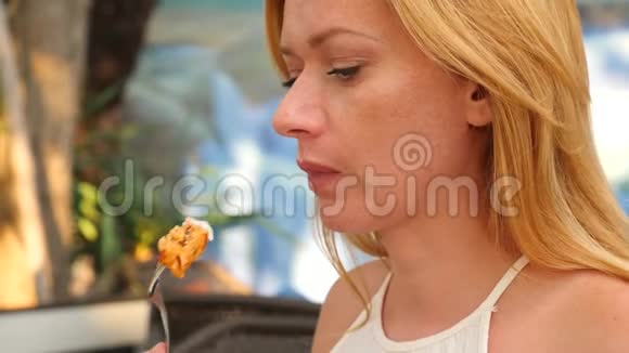 女人正用手在咖啡馆里吃什什烤肉串特写镜头4k慢镜头视频的预览图