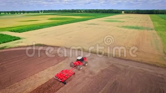 耕地上有耕用拖车的农用拖拉机视频的预览图