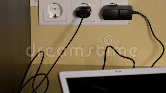 女性手插平板电脑和智能手机到墙插插座充电器视频的预览图