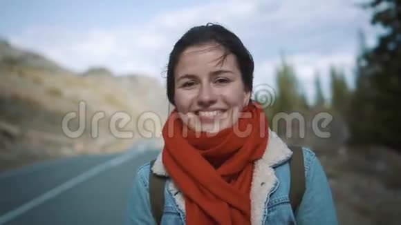 白种人女孩在白天站在两条车道的公路旁搭便车同时拿着纸板标志视频的预览图