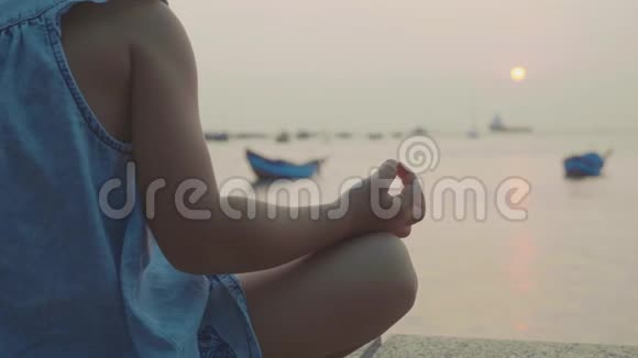 可爱的小女孩在海边以土耳其式冥想视频的预览图