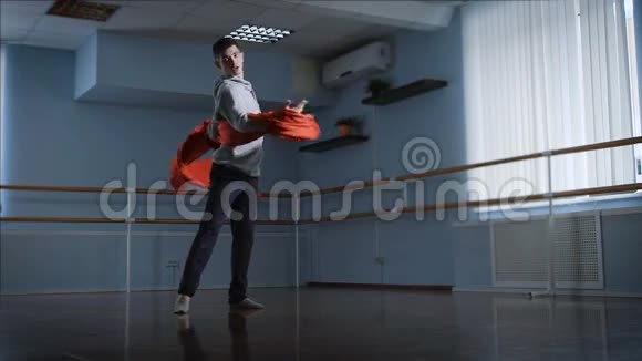 排练厅年轻的舞者他的动作表现为一种舞蹈现代主义风格他用红色的布料视频的预览图