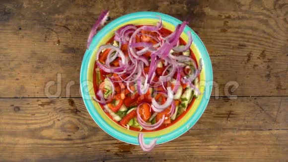 把切好的紫色洋葱和沙拉一起放在盘子里慢动作视频的预览图
