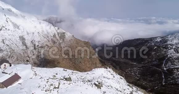 空中飞行在旅馆附近的雪山岭谷上空前进户外雪山野生视频的预览图