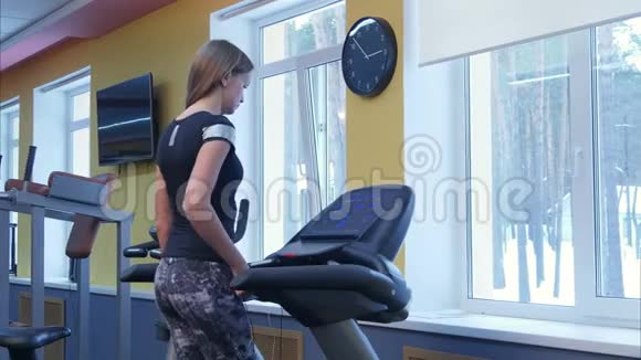 年轻女子在健身房跑步机上锻炼视频的预览图